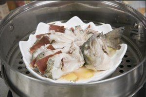 將鱸魚成花狀擺好，將火腿切片放入各縫隙中，放入鍋中隔水蒸12分鐘拿出，撒上蔥花即可。