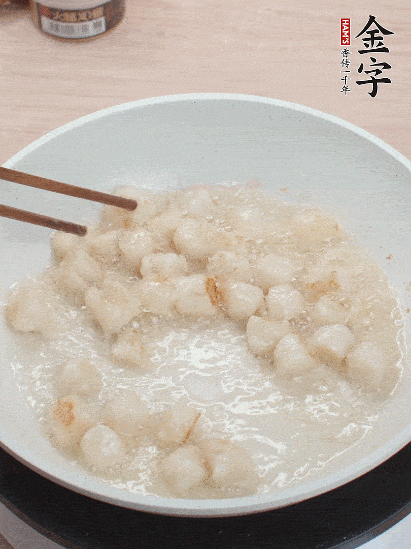 油溫4成熱，鮮貝蘸干淀粉下鍋煎，一面微黃后翻面。